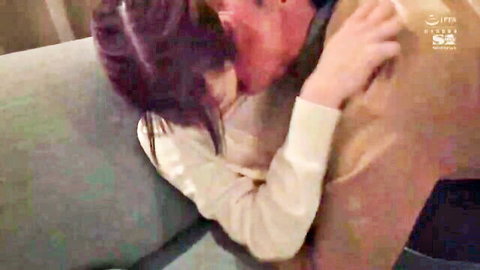 Purple-haired Asian woman in sweater kissing man passionately on couch