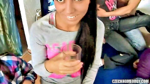 Amateur Czech babe in tight gray top holds pink drink smiling at wild home orgy party with guys