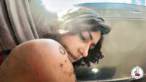 Tattooed brunette shows side boob lying sideways in train window seat