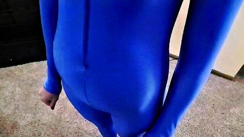 Slim girl in shiny blue full-body catsuit, obedient fetish pose