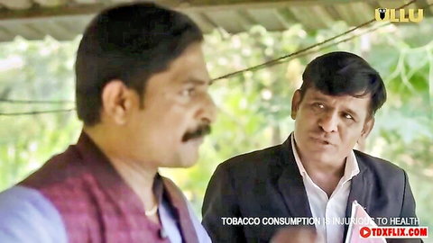 Two mature Indian men in kurta and suit facing each other in serious conversation