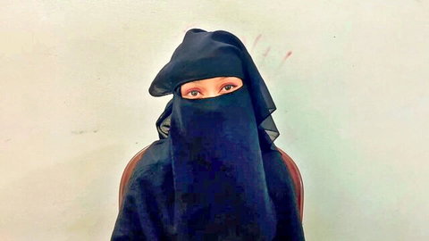 Veiled Indian manager in black niqab, mysterious eyes gazing