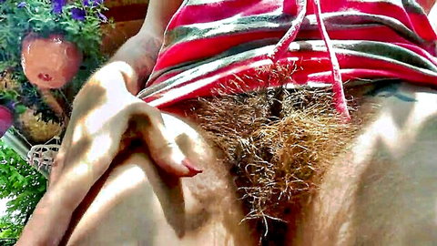 Outdoor close-up of hairy bush with hand spreading labia