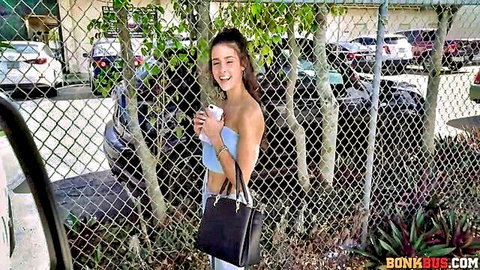Kylie Rocket smiling in cropped top and shorts outside fence