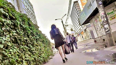 Thrilling upskirt view of brunette in short black skirt and hose on street
