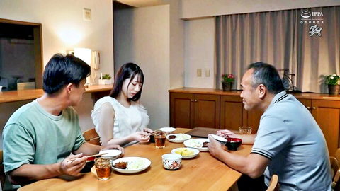 Young Japanese woman in white blouse eating dinner with two older Asian men at kitchen table