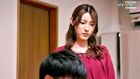 Kanako Iioka in red blouse standing over man in JAV boss nude model scene