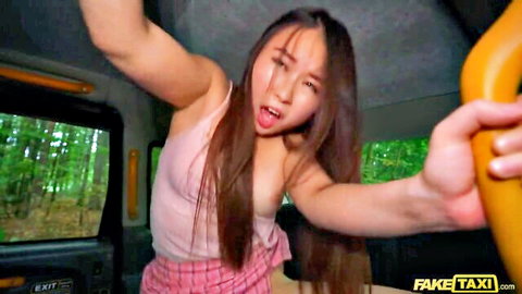 East Asian brunette sticks tongue out with skirt lifted teasing in FakeTaxi van