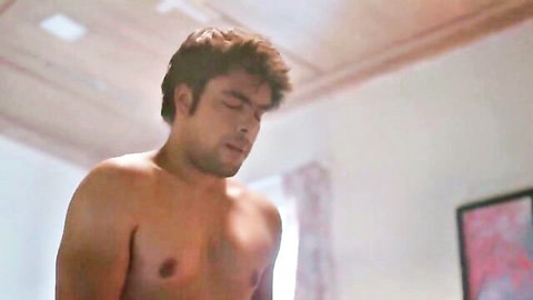 Handsome shirtless Indian guy showing muscular bare chest in bedroom