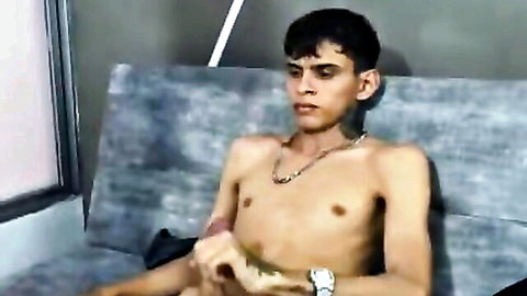 Shirtless slim Desi man sitting with hand near crotch in homemade couple video