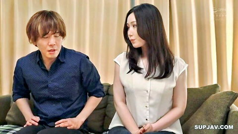 Asian JAV couple sitting close, man gesturing, woman smiling in white blouse