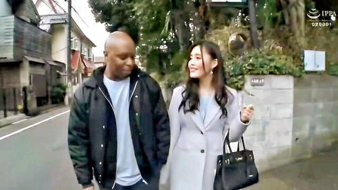 Interracial couple: Black man and curvy Asian wife walking intimately on Japanese street