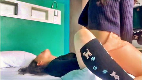 Intimate lesbian teen scene with one woman straddling another on bed, passionate embrace