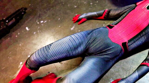 Spider-Woman in tight red and black superhero cosplay, lying on floor showing legs and ass