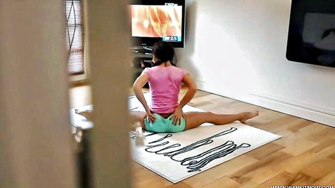 Flexible stepsister in tight pink top and green shorts spreads legs wide showing cameltoe and juicy ass watching porn on TV