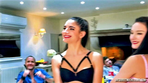 Two sexy women in black and pink lingerie smiling at party with excited men