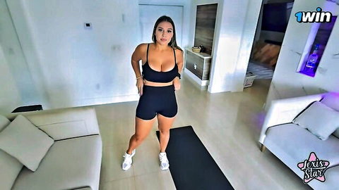 Curvy Latina with massive tits spilling from tight black sports bra posing in shorts on yoga mat