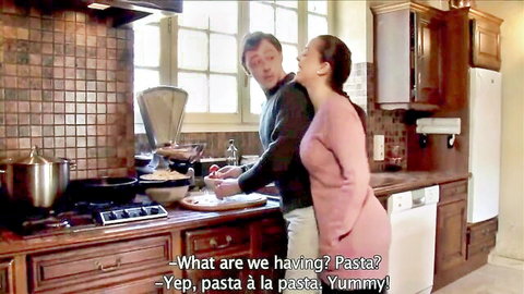 Couple teasing in kitchen while cooking pasta, playful adult foreplay
