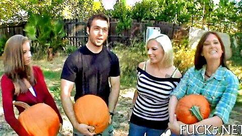 Group of smiling adults with pumpkins in erotic outdoor Halloween tease