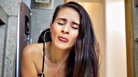 Stepmom with long dark hair, seductive expression in black top during stepson seduction