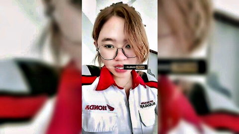 Cute Southeast Asian teen in glasses and Honda racing suit teasing with mouth open selfie