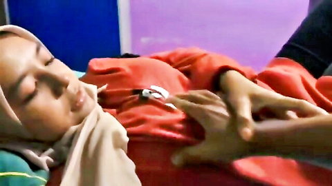 Hand groping big tits of sleeping hijab Malaysian girl in red top