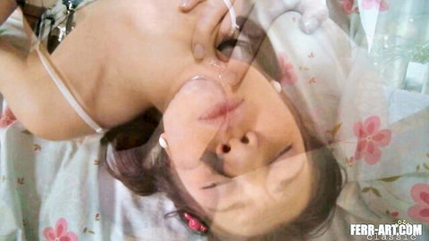 Busty Asian woman with exposed big tits arches back moaning with open mouth on pink bed