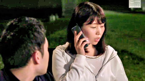 Asian wife in hoodie on phone during nighttime camping