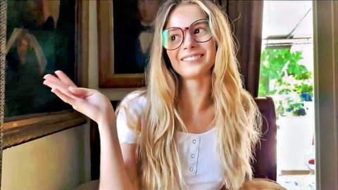 Skinny blonde stepsister in white top and glasses gesturing playfully