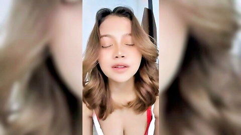 Close-up of sexy Indonesian teen with blonde hair, aroused face and cleavage in red top