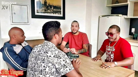 Four muscular Brazilian men sitting around kitchen table chatting casually