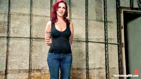 Redhead with big tits and tattoos poses seductively in basement wearing tight tank top and jeans