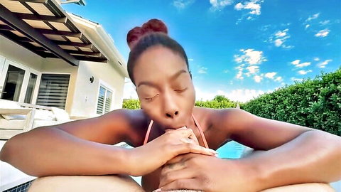 Ebony beauty in bikini lounging seductively by pool