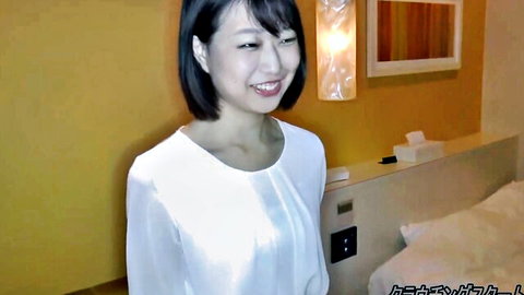Smiling Japanese brunette in sheer white blouse teasing in hotel room