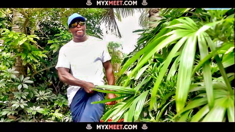 Smiling Black man in tropical jungle holding palm fronds, BBC teaser from Rich MILF gets Destroyed