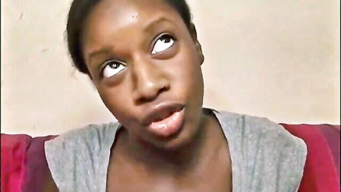 Ebony woman with wide surprised eyes, open mouth in gray sweater