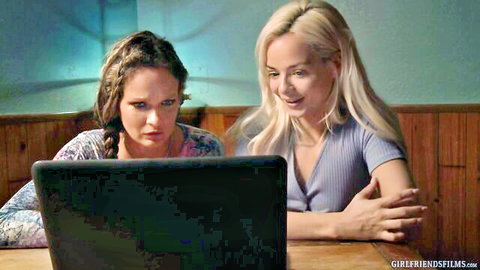 Brunette and blonde babes intently watching laptop screen together in lesbian tease