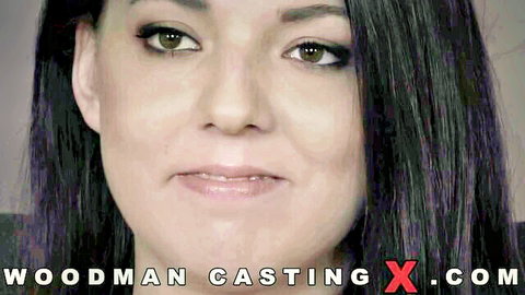 Closeup of sexy brunette with glossy lips smiling seductively in Woodman casting