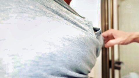 Asian woman in shiny gray top groped by hand near mirror