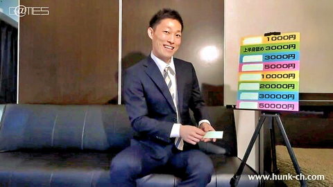 Handsome Japanese man in suit smiles in game show setup, erotic teaser