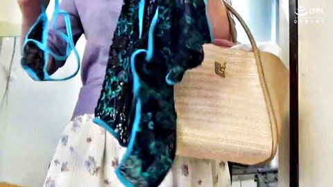 Mature Japanese woman holding blue lingerie bra and panties with elegant purse
