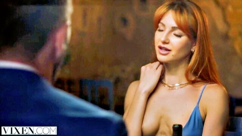 Seductive redhead babe in low-cut blue dress exposing massive tits to suited man at restaurant table