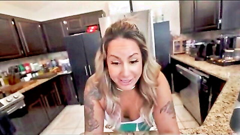 Tattooed blonde with cleavage in green top, teasing expression