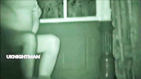 Nude brunette spreads legs fingering shaved pussy in night vision by window