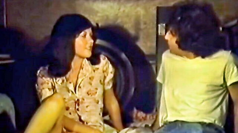 Vintage Asian woman in floral blouse chatting with man in retro porn scene