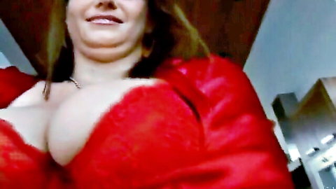 Sara Stone smiling with big cleavage in red furry jacket