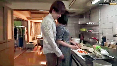Tall Asian man grinds against woman in tight dress from behind while she chops carrots in kitchen