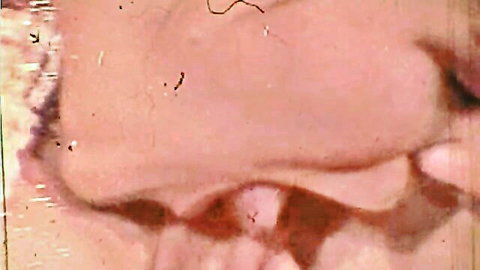 Close-up of woman's open mouth and tongue licking pink wet pussy lips in cunnilingus