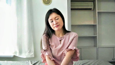 Asian G-cup wife in pink frilly blouse relaxing at home