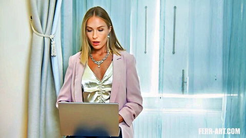 Blonde MILF in low-cut shiny blouse showing deep cleavage while using laptop